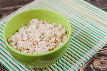 Oatmeal in Green Bowl on Wooden Table
