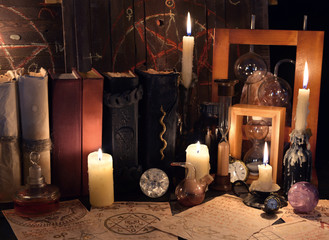 Witch table with magic objects, candles and old mystic parchments