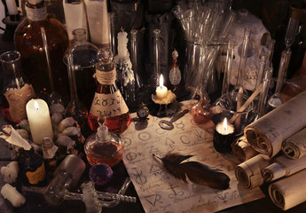 Mystic still life with alchemy paper, vintage bottles, candles and magic objects