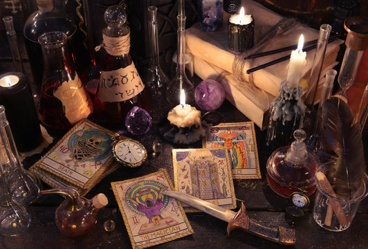 Still life with the tarot cards, knife, books and candles on witch table