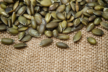 Pumpkin seeds on sack background