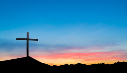 Cross on hill at sunset or sunrise