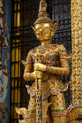 Gold yaksha demon at entrance to Phra Mondop library at historic Grand Palace in Bangkok, Thailand