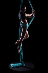 Young woman gymnast with blue gymnastic aerial silks