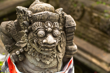 Fototapeta na wymiar Traditional demon guard statue carved in stone, Bali island, Indonesia.
