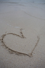 hearts drawn on the sand of a beach