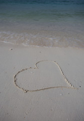 hearts drawn on the sand of a beach