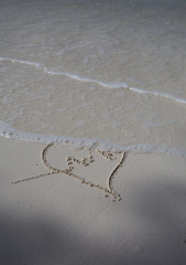 hearts drawn on the sand of a beach