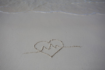 hearts drawn on the sand of a beach