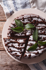 Freshly baked pie with poppy seeds and powdered sugar and mint close-up. vertical top view 
