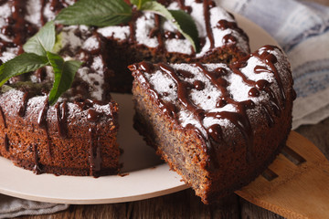 Tasty cake with poppy seeds and powdered sugar and mint close-up. horizontal
