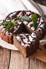 Freshly baked pie with poppy seeds and powdered sugar and mint close-up. vertical
