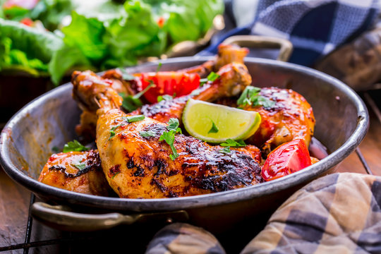Grilled chicken legs, lettuce and cherry tomatoes limet olives. Traditional cuisine. Mediterranean cuisine.