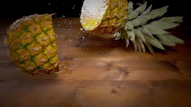 pineapple falling on table breaking in two halves slow motion