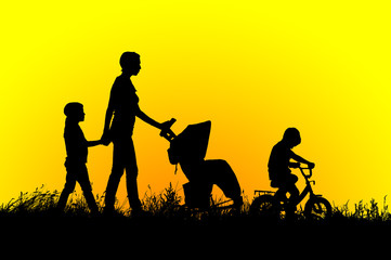 Fototapeta na wymiar Mother with stroller and children walking at sunset