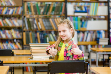 teen girl in library showing thumbs up