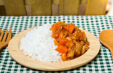 rice and spicy curry on wood plate