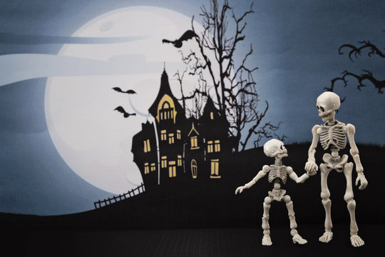 Skeleton and little skeleton with Halloween background