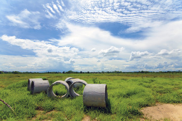 Obraz premium Concrete pipes on green meadow