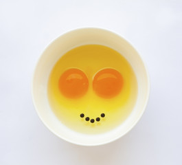 Egg yoks un-cooked in white bowl, solid white background