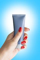 Plastic tube for cosmetics in female hand.