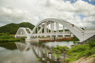Fototapeta na wymiar white railway bridge constructed on cloudy days at Lamphun, Thailand.
