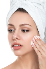 Portrait of young beautiful woman cleaning her face