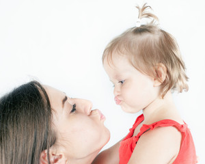 Close-up funny baby girl and her mother on white background