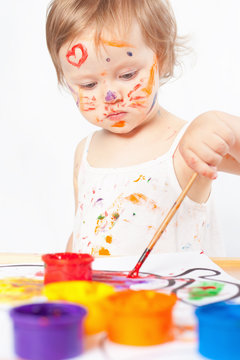 Baby draws with colored inks paint