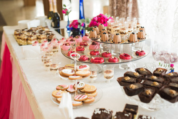 Delicious and tasty dessert table with cupcakes shots at reception closeup