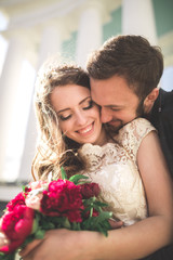 Beautiful couple, bride and groom posing near big white column