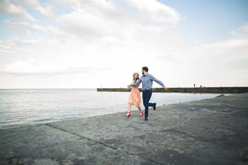 Fototapeta na wymiar Wedding couple, bride, groom walking and posing on pier