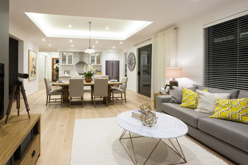 Modern living room including sofas and tables beside kitchen