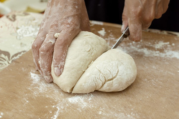 Obraz premium hands of the cook knife dough