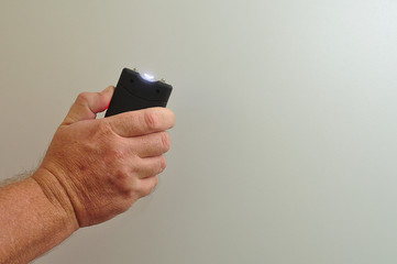 A taser held in a mans hand isolated on a white background