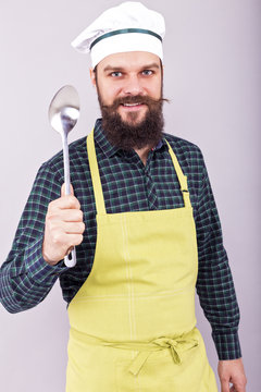 Portrait of a bearded chef holding a big spoon