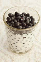 glass of bilberry with milk on a cloth