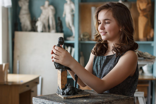 Teen Girl molds from clay sculpture in the artist's studio.