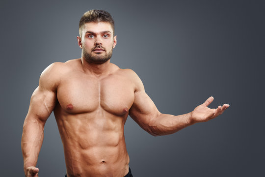 Muscular shirtless young man confused and shrug