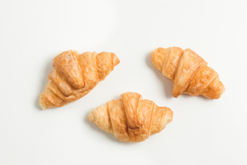 three gold croissant isolated on white background