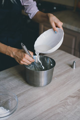Young woman chef cooking cake in kitchen