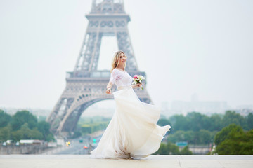 Beautiful bride in white dress near the Eiffel tower