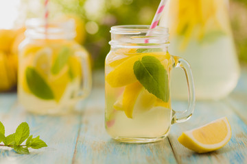 lemonade with mint on rocks served in jar with a straw