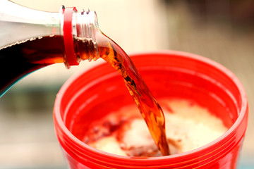 Cola with splash of ice cubes on white