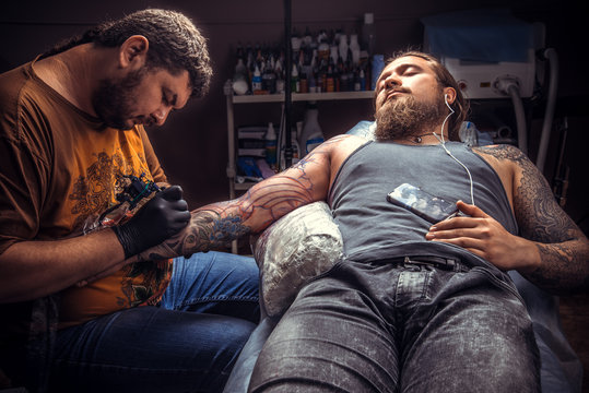 Professional tattoo artist working tattooing in tattoo parlour
