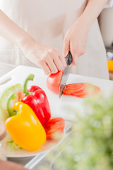 エプロンを着た女性、トマトを切る