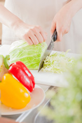 エプロンを着た女性、キャベツを切る