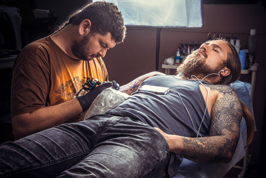 Professional tattooist posing in tattoo parlour