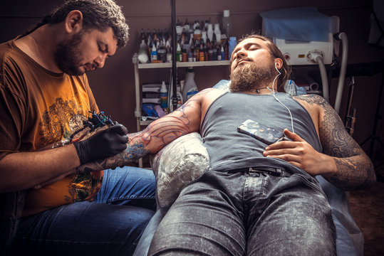 Tattoo artist makes tattoo in tattoo studio