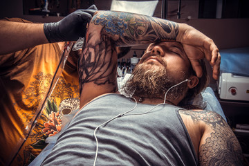 Tattoo artist makes tattoo in salon